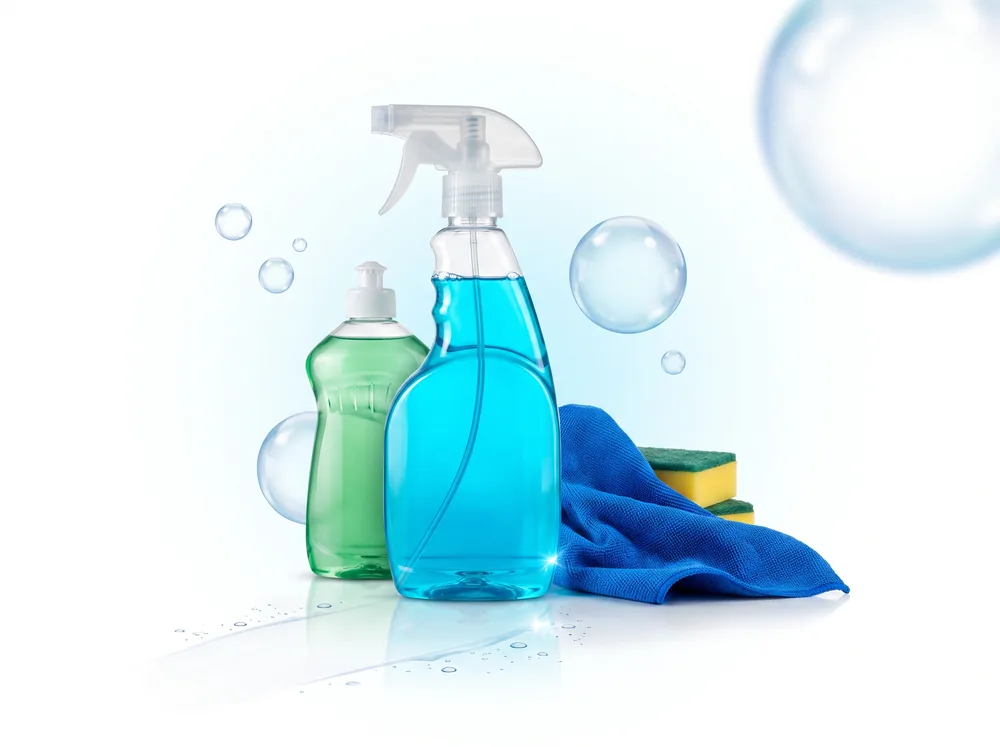 Cena de estilo base com spray, detergente e pano em fundo claro